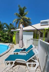 a couple of lounge chairs next to a swimming pool at Logisrev in Sainte-Anne