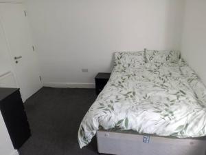 a bed in a room with a white wall at Ensuite Double-bed (G3) close to Burnley city centre in Burnley