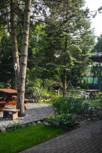 a park with a picnic table and benches and trees at Pokoje gościnne „SEN” in Iława