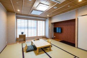 a conference room with a table and chairs and a large window at Ryokan Ginkaku Kyoto in Kyoto