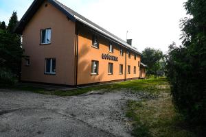 a building with the sun shining on the side of it at Pokoje gościnne „SEN” in Iława
