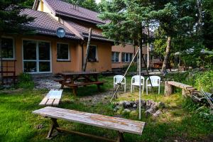 een picknicktafel en stoelen in de tuin van een huis bij Pokoje gościnne „SEN” in Iława