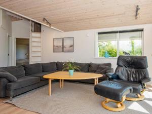 a living room with a couch and a table and a chair at 6 person holiday home in Hemmet in Falen