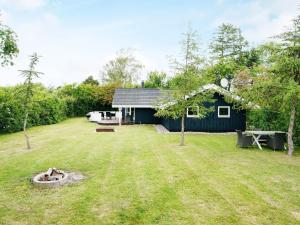 a house with a yard with a fire pit at Four-Bedroom Holiday home in Slagelse 2 in Store Kongsmark