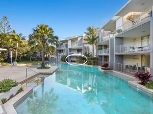 a swimming pool in a apartment complex with a large swimming pool at Drift North Beachfront Apartments - Private Apartments in Kingscliff