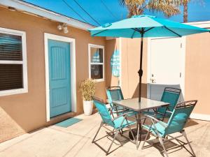 - une table et des chaises avec un parasol sur la terrasse dans l'établissement Cozy Beach Cottage with Bicycles, à San Diego