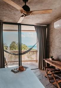 um quarto com uma cama e vista para o oceano em DOS MARES Pool Club Boutique Hotel em El Cuyo