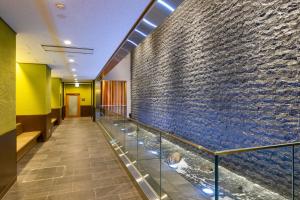 un long couloir avec un grand mur de pierre dans l'établissement Ryokan Ginkaku Kyoto, à Kyoto