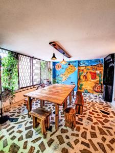uma sala de jantar com uma mesa de madeira e bancos em Yosu Hostal em Ríohacha