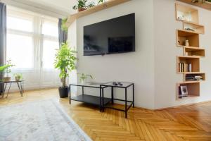 sala de estar con mesa negra y TV en la pared en Dohany Design Apartments, en Budapest