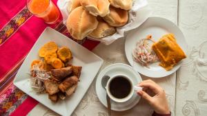 a table with plates of food and a cup of coffee at Eco Hotel Villa Suites in Quillabamba