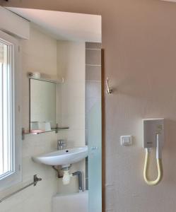 a bathroom with a sink and a mirror at Hotel Les Rosiers in La Rochelle