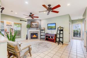 sala de estar con chimenea y ventilador de techo en Whispering Pines 124, en Pigeon Forge