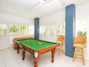 a room with a pool table and two chairs at Noosa Dua Apartment 1, Noosaville in Noosaville
