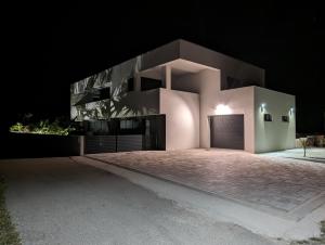 a large house with a garage at night at Villa SunSet in Privlaka