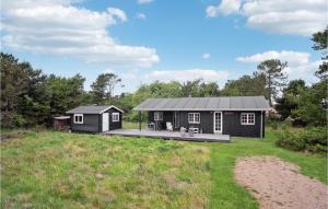 a black tiny house with a deck in a field at Stunning Home In Fan With 2 Bedrooms And Wifi in Fanø