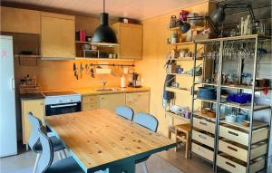 a kitchen with a wooden table and chairs at Awesome Apartment In Fvang With Wifi And 3 Bedrooms in Favang