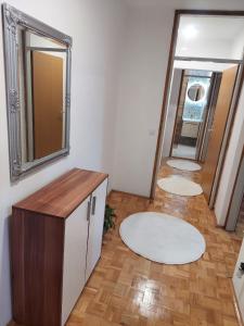 baño con 2 espejos y suelo de madera en Apartman Minja, en Višegrad
