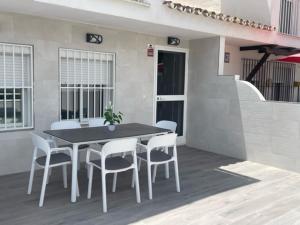 a black table and white chairs on a patio at Malaga Chalet en Guadalmar in Málaga