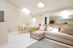a living room with a couch and a kitchen at Timeless Loft at the Village in Ericeira