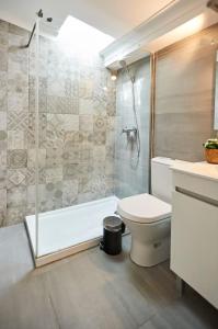 a bathroom with a shower and a toilet and a sink at Timeless Loft at the Village in Ericeira