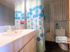 a bathroom with a sink and a shower curtain at Sun Beach Acantilados La Mar in Salou