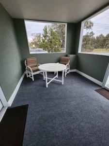 Habitación con mesa, 2 sillas y 2 ventanas en Cute and Comfy with porch, en Lakeland