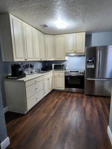 una cocina con armarios blancos y electrodomésticos de acero inoxidable en Cute and Comfy with porch, en Lakeland