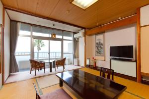 a living room with a dining table and a television at Boyokaku in Amakusa
