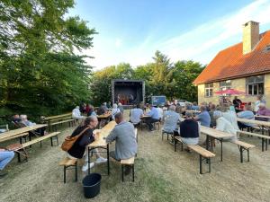 a crowd of people sitting at tables watching a stage at Room 8 - Hawkraft kulturhotel in Vestervig +10 photos
