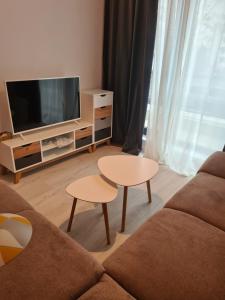 sala de estar con sofá, TV y mesas en apartament 2 camere superb, en Bucarest