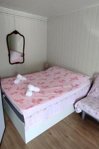 Studio Punat 5410a في بونات: غرفة نوم مع سرير وملاءات وردية ومرآة