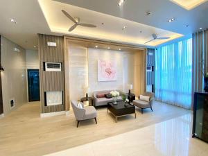 a living room with a couch and chairs and a tv at Bloom Residences Condo 2Br in Manila