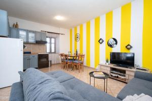 uma sala de estar com um sofá azul e riscas amarelas e brancas em Apartments with a parking space Preko, Ugljan - 8179 em Preko