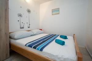 a bedroom with a bed with blue pillows on it at Apartments with a parking space Preko, Ugljan - 8179 in Preko