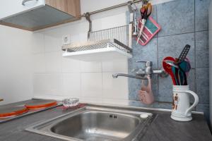 a kitchen sink with a utensils in a cup at Apartment Preko 8179b in Preko