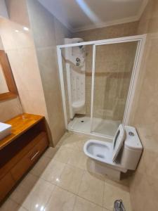 a bathroom with a white toilet and a shower at Arcos de Valdevez, Recanto da Prova - PNPG in Arcos de Valdevez