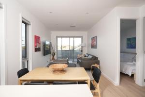 a dining room and living room with a table and chairs at Powder Peaks in Jindabyne