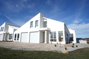 a white house with a large driveway at Powder Peaks in Jindabyne
