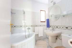 Baño blanco con bañera y lavamanos en Apartments with a parking space Kastel Stari, Kastela - 20999, en Kaštela