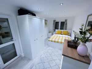 a white bedroom with a bed and a table at (ZONE 2) CONTEMPORARY 2 BED FLAT HEART OF LEWISHAM in London