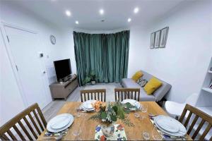 a living room with a table with chairs and a couch at (ZONE 2) CONTEMPORARY 2 BED FLAT HEART OF LEWISHAM in London
