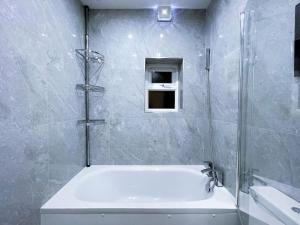 a bathroom with a shower with a tub and a sink at (ZONE 2) CONTEMPORARY 2 BED FLAT HEART OF LEWISHAM in London