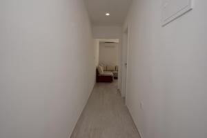 - un couloir blanc avec un canapé dans l'établissement Apartments with a parking space Split - 21525, à Split