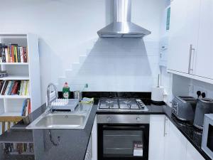 a kitchen with a sink and a stove top oven at (ZONE 2) CONTEMPORARY 2 BED FLAT HEART OF LEWISHAM in London