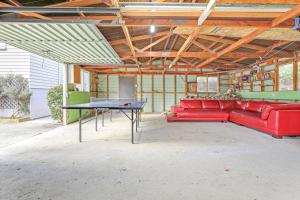 a red couch and ping pong table in a garage at Redwoods Retreat in Rotorua