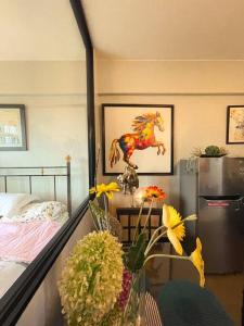 a room with a bed and a table with flowers at Lovely & Stylish 1BR in Mckinley Hill with View in Manila