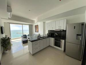 cocina con armarios blancos y vistas al océano en Apartamentos Palmetto Eliptic ICDI, en Cartagena de Indias