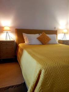a bedroom with a large bed with two lamps at Oliveira Country House in Figueira e Barros