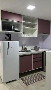 a kitchen with a white refrigerator and a sink at Eco Paradise 110 - Cumbuco in Caucaia